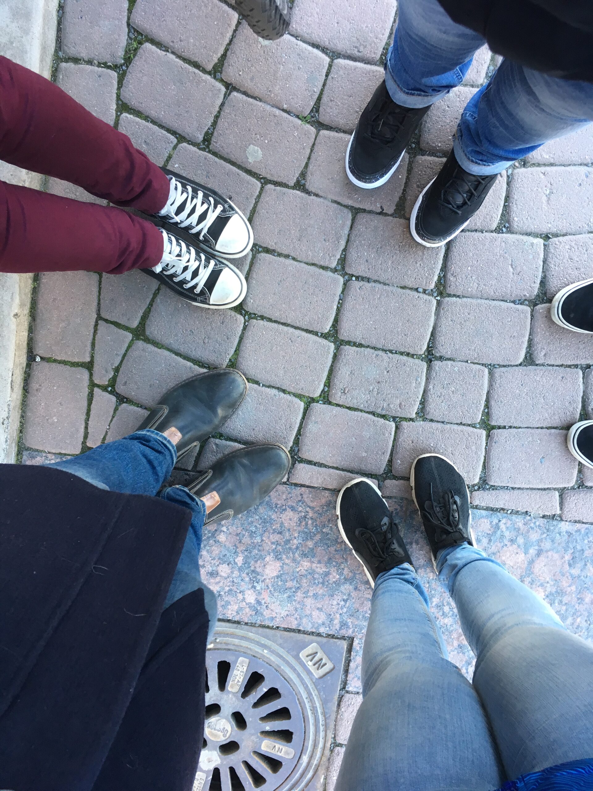 Kuvituskuva, jossa ihmisten jalkoja piirissä kivetyksellä