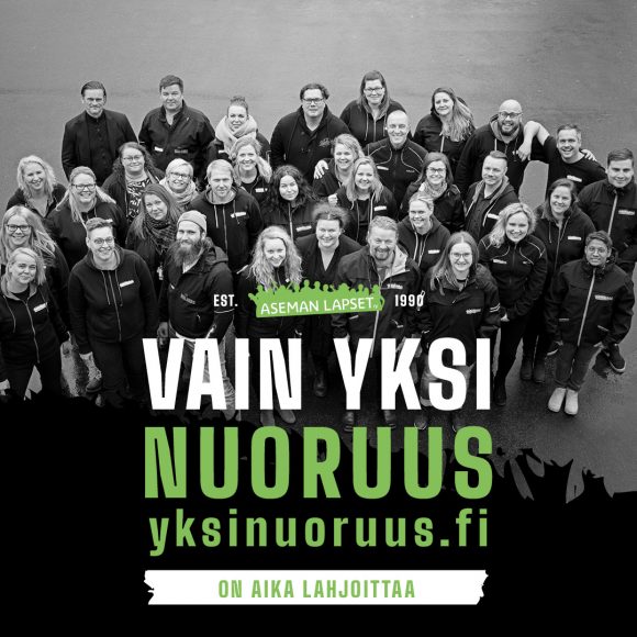 Työntekijöitä iso joukko katsoo ylöspäin kameraan